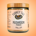 Load image into Gallery viewer, Jar of turkey tail mushroom powder with a label on an orange background
