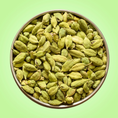 Load image into Gallery viewer, Bowl of green cardamom pods on a green background
