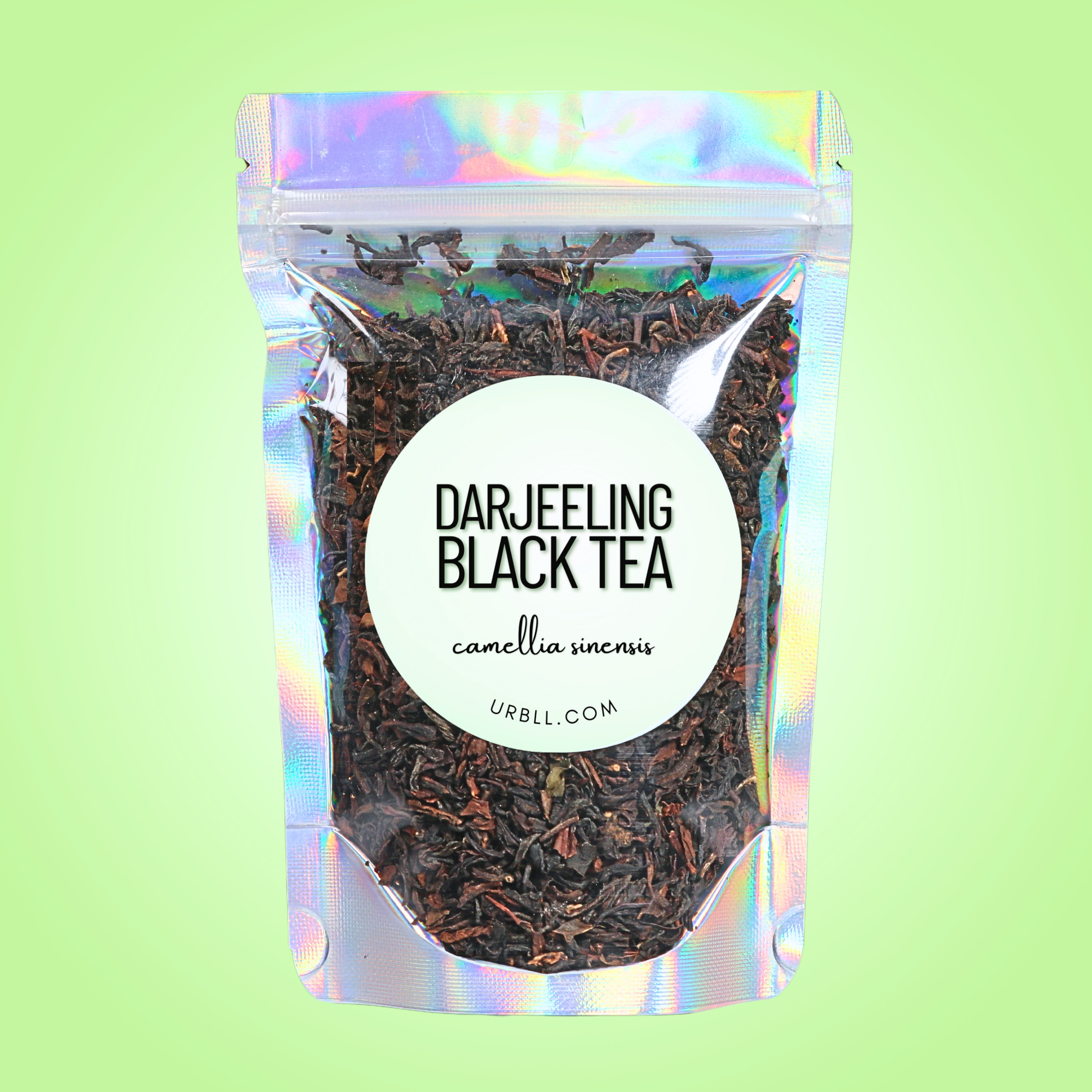 Packaged Darjeeling black tea with a colorful holographic sleeve on a light green background