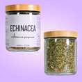 Load image into Gallery viewer, Two glass jars with wooden lids on a purple background, one labeled 'Echinacea' and the other containing dried herbs.
