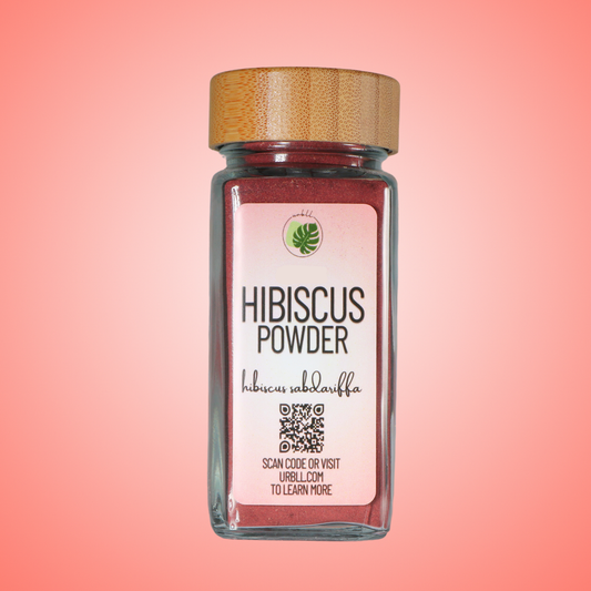 Jar of hibiscus powder with a wooden lid on a pink background
